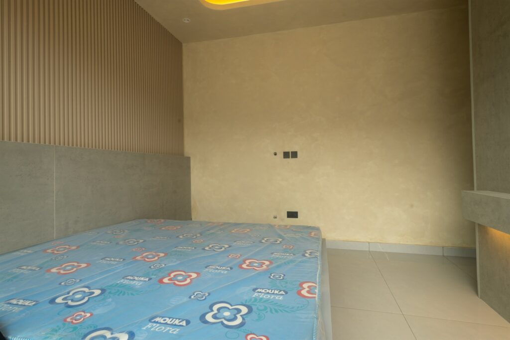 Brum Height 9: Bedroom with an upholstered bed and fluted wall detail